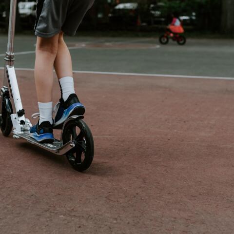 Unga fotbollstalanger tränar balans och koordination med sparkcykel vid sidan av planen